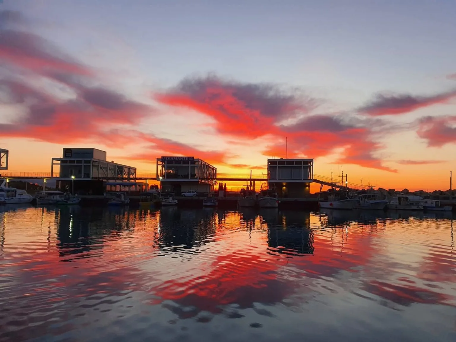 Sunset over Limassol Marina reflected on the water