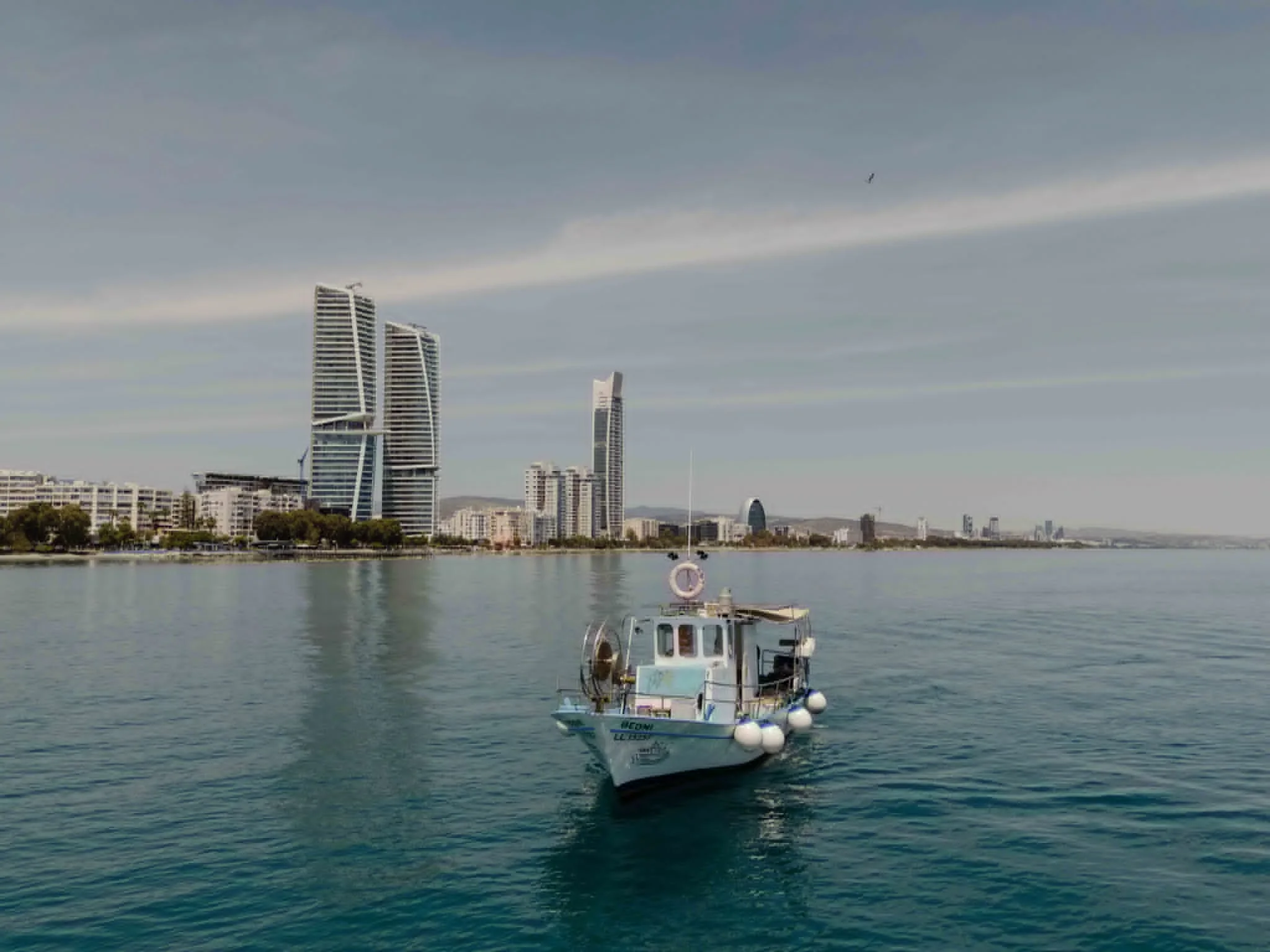 Theoni traditional fishing boat with the Limassol skyline